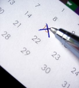 Pen marking off date on calendar