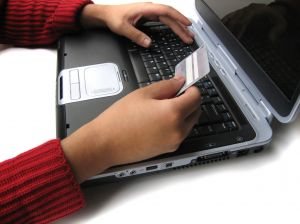 Person on laptop typing in card information