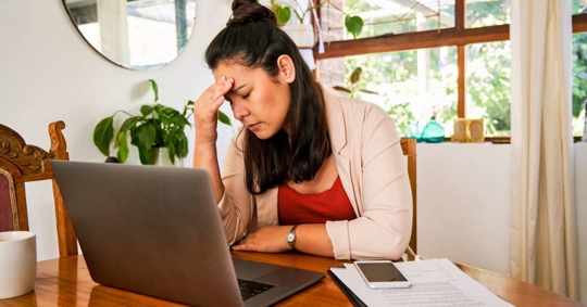woman looking stressed while managing finances