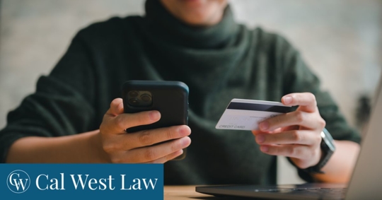 Person holding credit card and phone