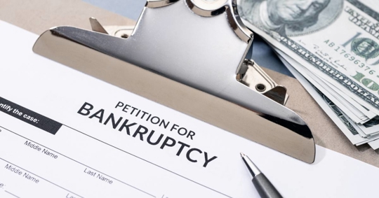 Petition for Bankruptcy form and pen on desk