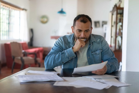 Man Looking Concerned at Documents