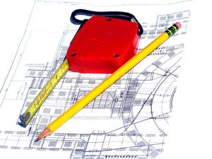 Measuring tape and pencil on top of blueprints 